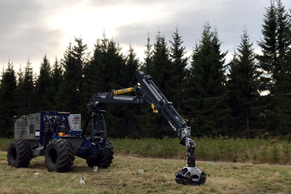 Autonomous planting machine with spruce forest behind. Photo.