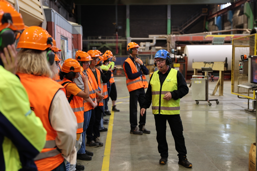 Person guiding group in paper mill. Photo.